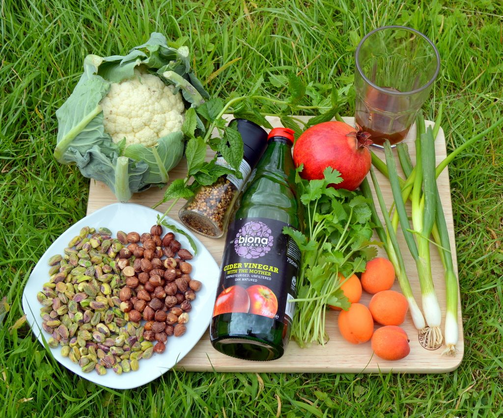 ingredients for Fruity nutty cauliflower couscous crunch including apricots, pistachios, hazelnuts, apple cider vinegar and spring onions.