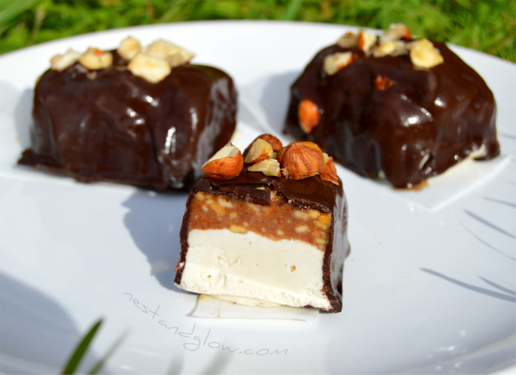 snickers raw vegan ice cream on a plate and cut with a knife to show the crunchy almond butter caramel. Everyone loves these dairy free amazing ice cream bars