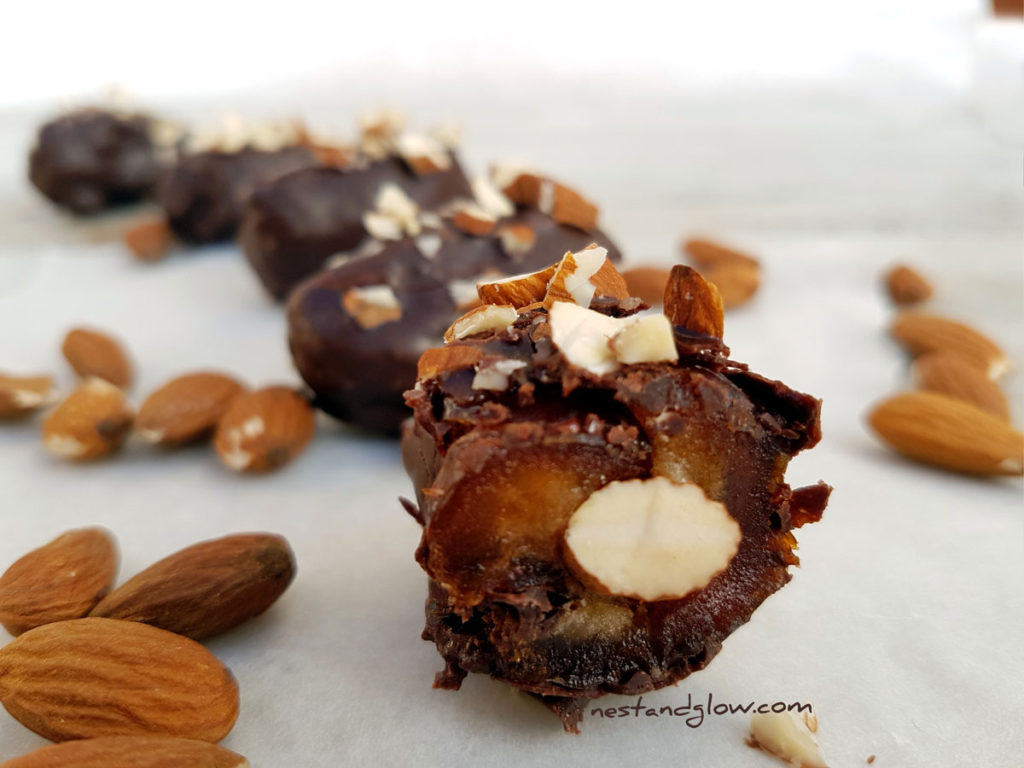 Half eaten Almond Stuffed Medula Dates Dipped in Raw Chocolate
