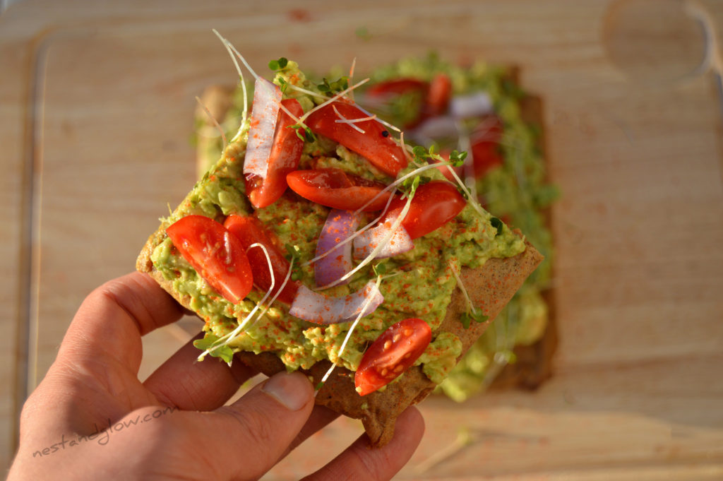 A slice of avocado toast on made from gluten free quinoa bread