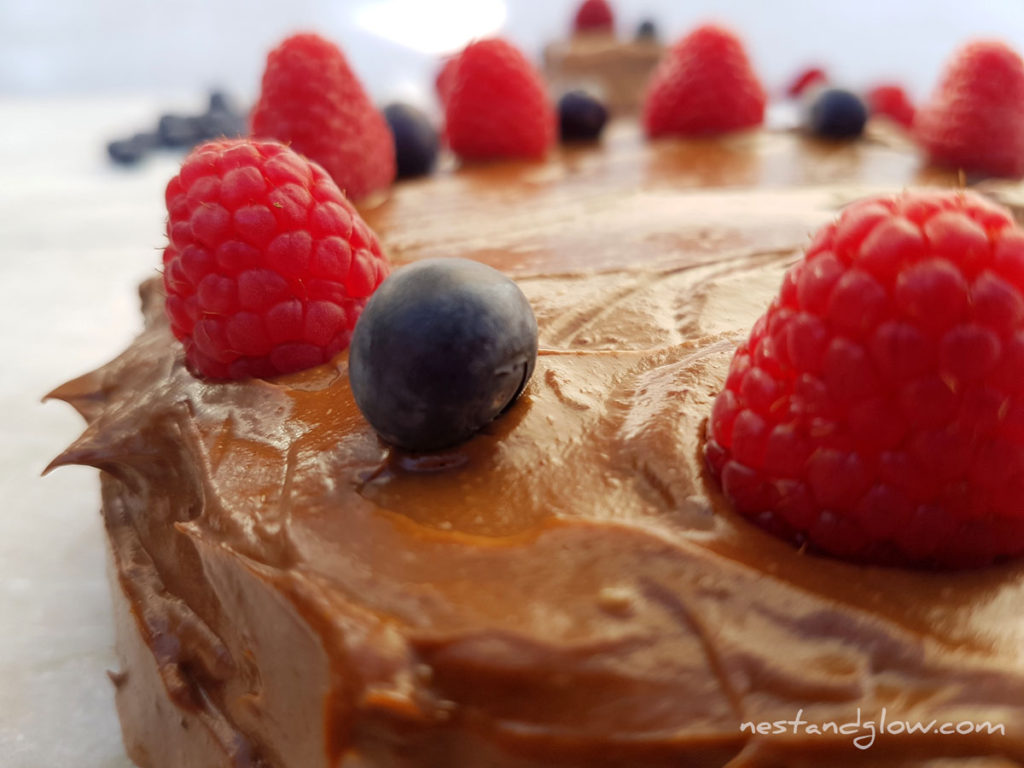 Quinoa Chocolate Cake With avocado frosting, raspberries and blueberries close up