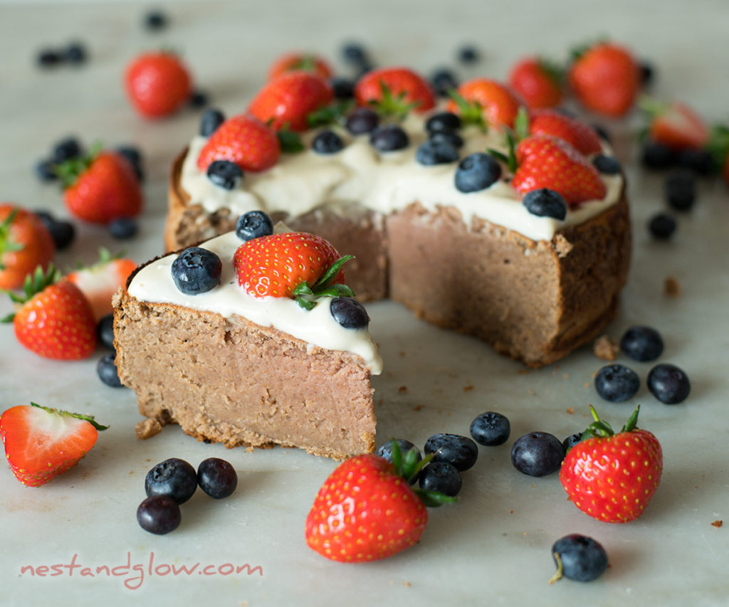 healthy chickpea strawberry cake topped with coconut vanilla frosting and berries. Try this simple gluten free recipe that's inexpensive to make