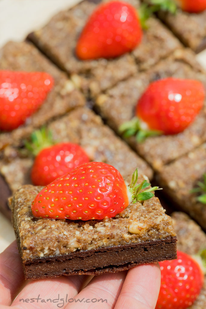 strawberries on top of a high protein vegan brownie. no oil, no butter and no junk in this healthy chocolate brownie
