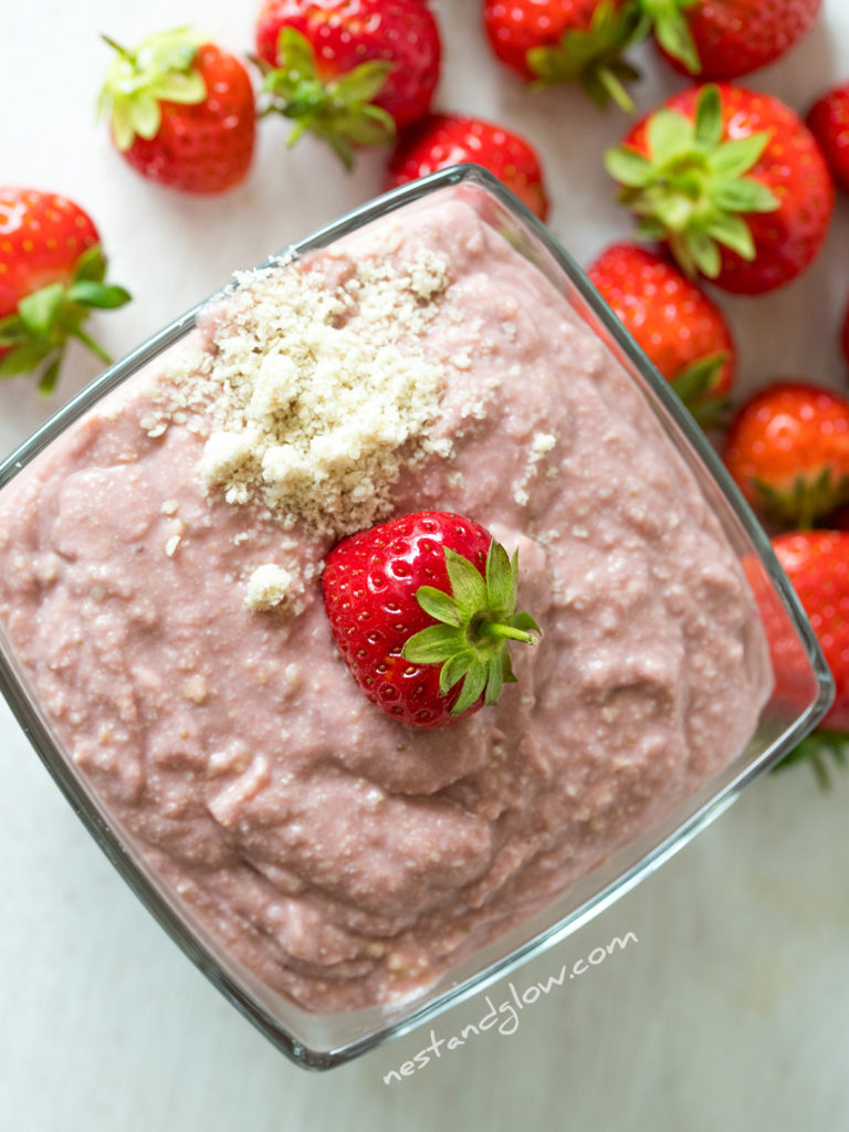 strawberry hummus topped with a fresh berry and a sprinkle of ground sesame seeds. this looks like porridge but is a decadent dessert hummus