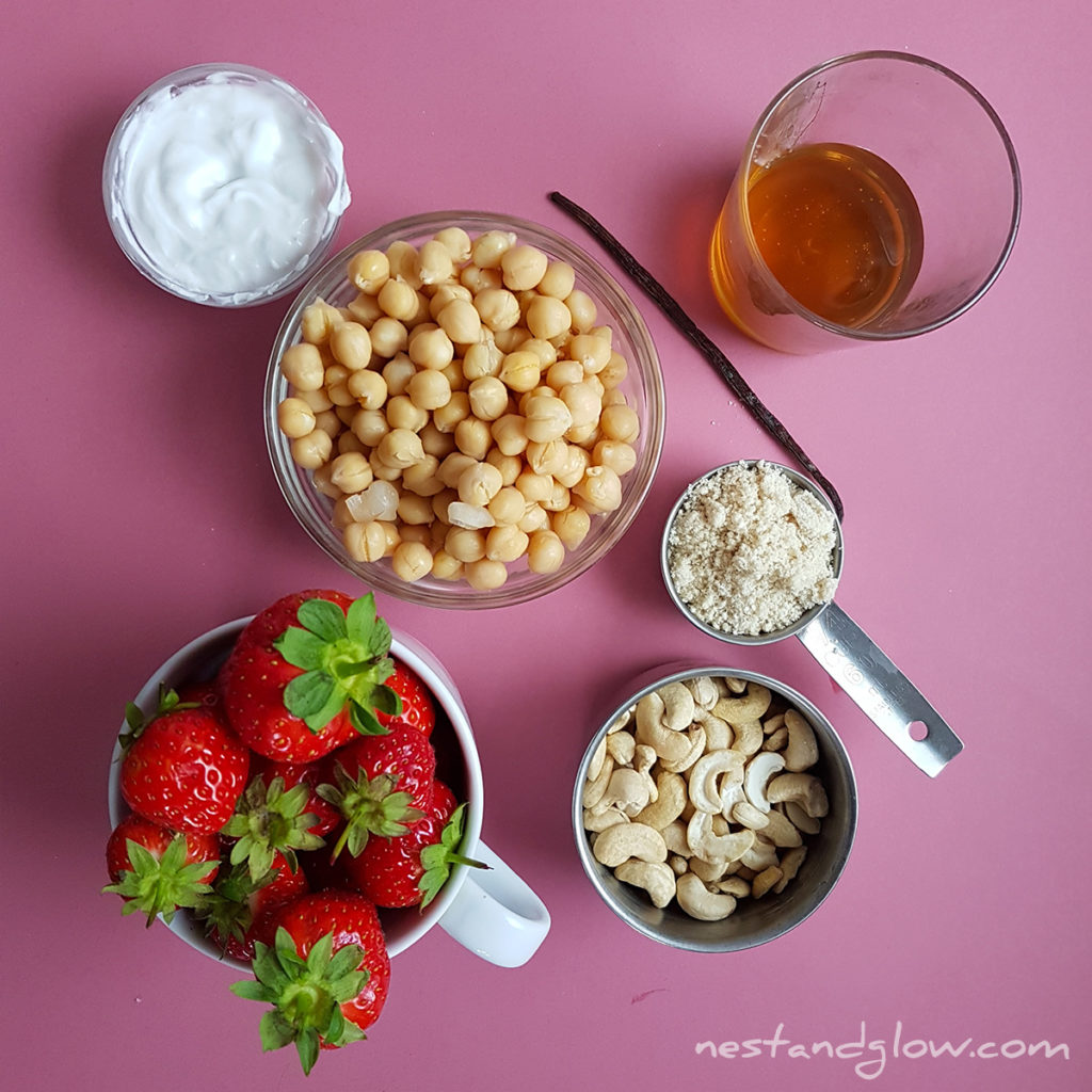 the ingredients for strawberry cheesecake hummus include vanilla, cashews, coconut, maple syrup, strawberries and sesame seeds. Super easy and healthy dessert hummus recipe