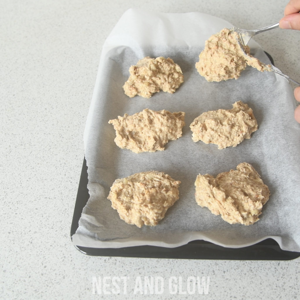 spooning peanut butter cookies onto a baking tray