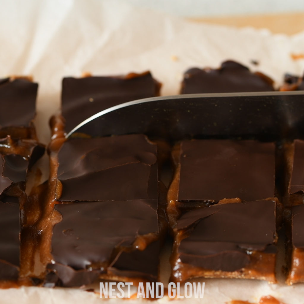 cutting this healthy chocolate caramel shortbread can be a bit messy. But it tastes so good it's really worth it!