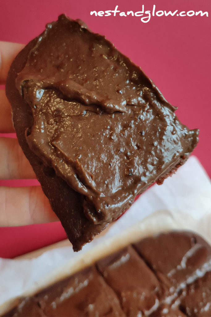 a slice of gluten free quinoa brownie that's topped with a healthy oil free frosting. high in protein vegan brownie
